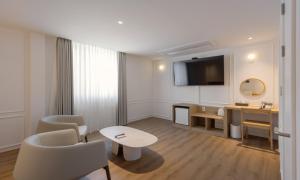 a living room with a table and chairs and a television at Chuncheon Bom Stay in Chuncheon