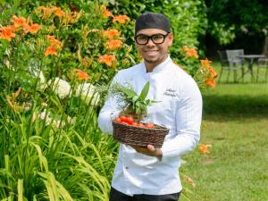 a man is holding a basket of tomatoes at Novotel Milano Linate Aeroporto in Milan