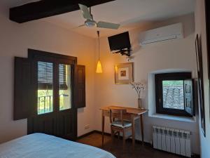 a bedroom with a bed and a table and a window at Casa Rural Hosteria Cantarranas in Cuacos de Yuste