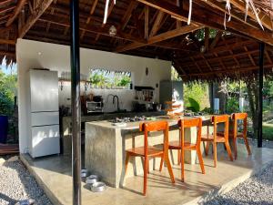 a kitchen with orange chairs and a table with a counter at Farm Village in San Juan