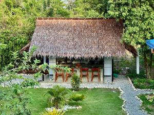 a hut with a table and chairs in a garden at Farm Village in San Juan