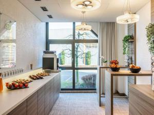 a kitchen with a counter with food on it at ibis Lausanne Crissier in Lausanne