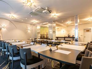 a dining room with tables and chairs and lights at Mercure Paris Place d'Italie in Paris