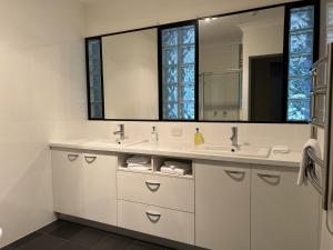 a bathroom with two sinks and a large mirror at Invercauld House in Goonellabah
