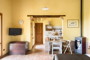 uma sala de estar com uma mesa e um fogão em Un Petit Paradis em Castiglione della Valle