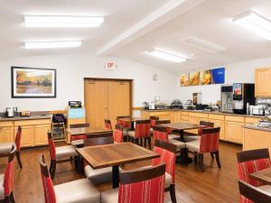 a restaurant with tables and chairs and a kitchen at Comfort Inn Iron Mountain North in Iron Mountain
