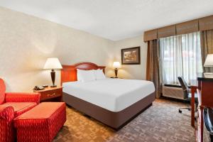 a hotel room with a bed and a chair at Quality Inn Edison-New Brunswick in Edison +42 photos