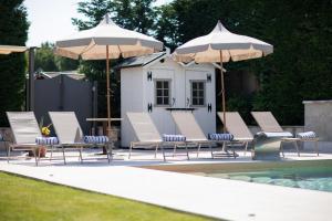 a group of chairs and umbrellas next to a pool at Residence Cà di Capri in Bussolengo
