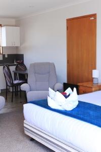 a hotel room with a bed and a chair at Baywatch Motor Lodge in Timaru