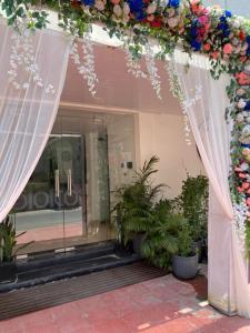 an arch with flowers and plants in front of a store at Hotel The Amrit in Jabalpur