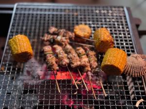 a bunch of meat and corn on a grill at 아라무사aramoosa민숙 in Tsushima