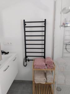 a bathroom with a rack of towels on a shelf at Au pays des cigognes in Cambron-Casteau +24 photos