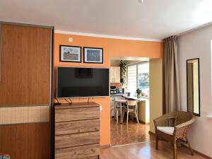 a living room with a flat screen tv on a wall at Nidos Laivas in Nida