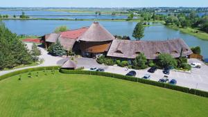 an aerial view of a large building with a large lake at KARPYNĖ Restaurant & Bed & Breakfast in Gabšiai