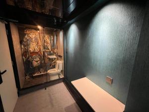 a bathroom with a toilet and a painting on the wall at Where Inn in Hong Kong