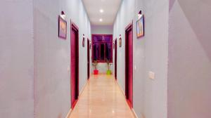a hallway with red and white walls and a long aisle at Asapian Vanyamahal - A Nature Resort in Rāmnagar