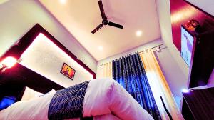 a bedroom with a bed and a ceiling fan at Asapian Vanyamahal - A Nature Resort in Rāmnagar