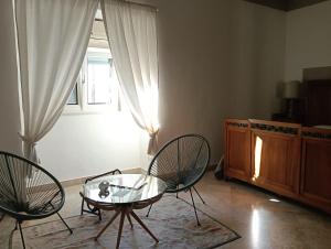a living room with two chairs and a table and a window at B&B Liberty in Andria