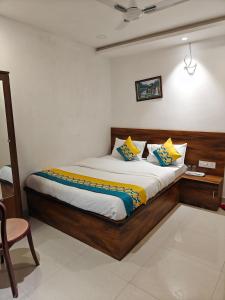 a bedroom with a large bed with yellow and blue pillows at Hotel Parineeta in Khagaria