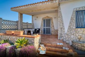 a house with a stone wall and a patio at Casa Vacanza California in Bari