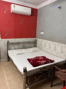 a bed in a room with a red wall at Hotel Shabnam,Near Park St,New Market,Esplanade in Kolkata