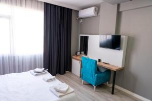 a hotel room with a bed and a desk and a television at RİO's HOTEL KURTKÖY in Istanbul