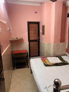 a small room with a bed and a table at Hotel Shabnam,Near Park St,New Market,Esplanade in Kolkata
