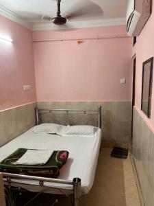 a bed in a room with pink walls at Hotel Shabnam,Near Park St,New Market,Esplanade in Kolkata