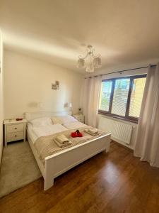a bedroom with a large white bed and a window at Apartmán Lara -Lesná in Stará Lesná +31 photos