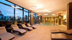 a large room with chairs and a pool and windows at Apartmán Lara -Lesná in Stará Lesná