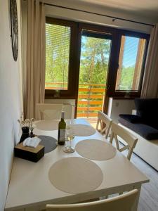 a dining room table with a bottle of wine on it at Apartmán Lara -Lesná in Stará Lesná