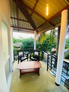 a porch with a table and chairs on it at New Vilard in Tissamaharama