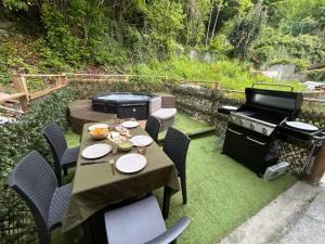 a patio with a grill and a table and chairs at Il caminetto in Pradleve