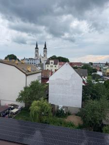 a view of a city with a white building and some buildings at Apartament Centrum in Augustów
