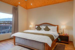 a bedroom with a large bed and a large window at Reejas inn's n' suites in Kasauli +66 photos