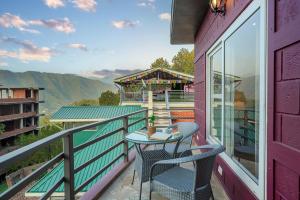 a patio with two chairs and a table on a balcony at Reejas inn's n' suites in Kasauli
