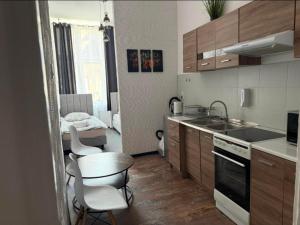 a kitchen with a sink and a table and chairs at Apartament X in Przemyśl