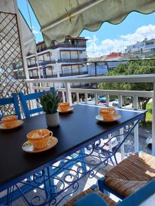 a blue table on a balcony with bowls and chairs at Apartment Natasha in Paralia Katerinis