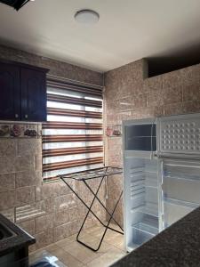 a kitchen with an empty refrigerator and a window at Robou Al Sharq in Amman