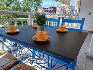 a black table with four cups and saucers on a balcony at Apartment Natasha in Paralia Katerinis