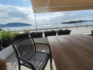 a wooden table and chair on a balcony with a view of the ocean at Aurora suite in Nea Peramos