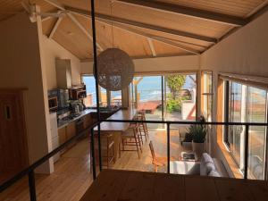 a kitchen and living room with a view of the ocean at 丘の上の小さなスローリゾート フェニックスの宿 in Miyazaki