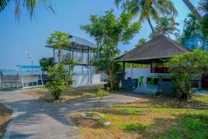 a building with a gazebo and a tree at Mannath Lake House in Murinjupuzha