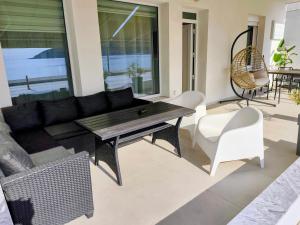 a living room with a couch and a table and chairs at Aurora suite in Nea Peramos