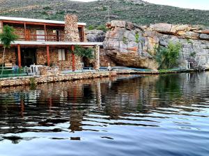 a house sitting next to a body of water at Rondeberg Holiday Resort in Clanwilliam