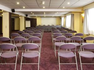 a room with rows of chairs and a projection screen at Mercure Mont Saint Michel in Le Mont Saint Michel