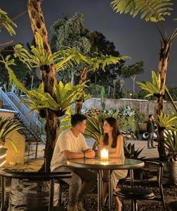 a man and a woman sitting at a table at Bwalk Hotel & Villa Malang in Sengkaling