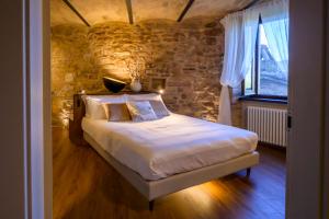 a bedroom with a bed with a stone wall at Charme in Spello in Spello