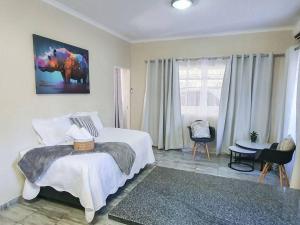 a bedroom with a bed and a table and a window at Hippo's Rest in Ellisras