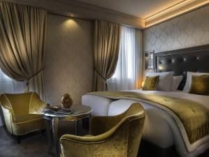 a hotel room with a large bed and two chairs at Papadopoli Hotel Venezia - MGallery Collection in Venice +219 photos